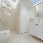 Professionele loodgieter werkzaam in badkamer met gereedschap voor leidingreparatie en renovatie