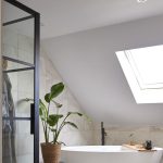 Luxe badkamer op zolder met schuine daken en dakraam