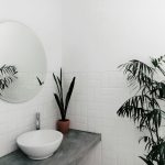 Modern ingerichte wasruimte in badkamer met compacte wasmachine en droger onder werkblad