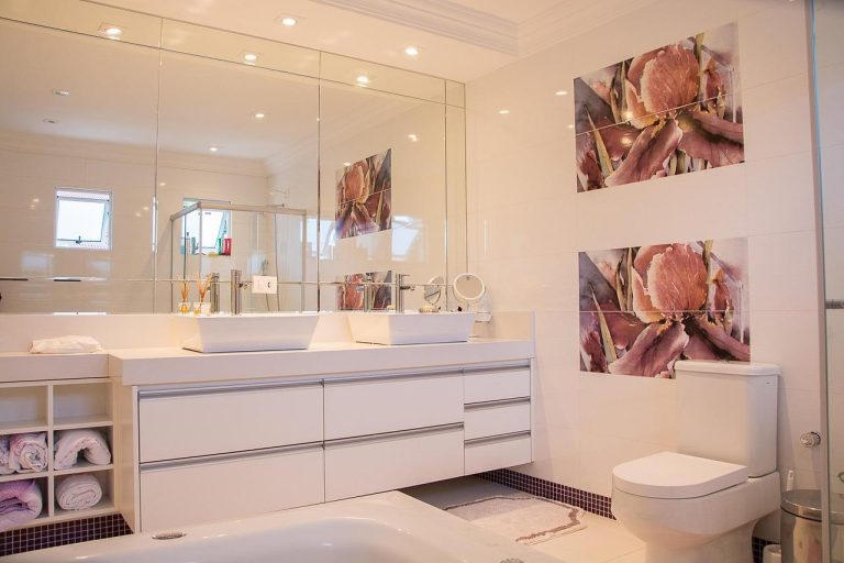 Moderne badkamer met sfeervolle inrichting: kunststof panelen, groene planten, warme verlichting en houten accessoires
