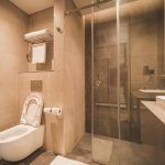 Luxe natuursteen tegels in badkamer met structuur op vloer en gladde tegels op wand voor veiligheid en elegantie