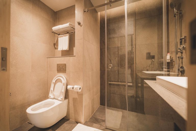 Luxe natuursteen tegels in badkamer met structuur op vloer en gladde tegels op wand voor veiligheid en elegantie